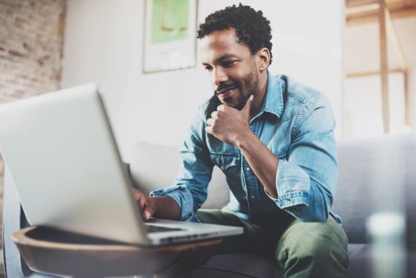 Man sitting on couch running a Facebook ads business from home